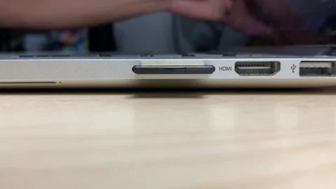 Inserting SD card into slot socket notebook on wooden table desk Stock Footage 250403260