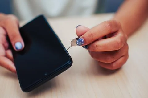 Inserting sim card into smartphone home setting tech tutorial close-up view.. Foto stock