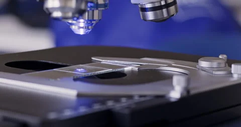 Inserting slide under lens of laser microscope in laboratory Video stock 273913497