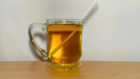 Inserting straw into clear glass of sweet fruity apple juice on wooden tabl.. Stock Footage 318126091