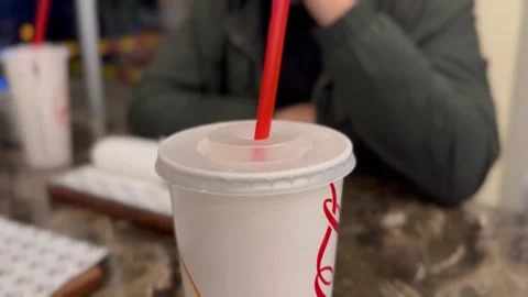 Inserting a Straw into a Fizzy Drink at a Fast Food Restaurant Stock Footage 297730781