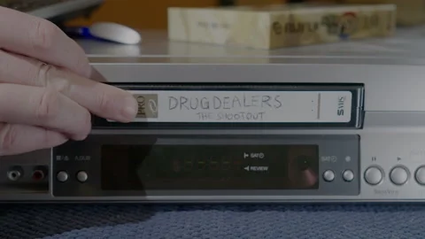 Inserting tape into vintage VHS player Stock Footage 229190744