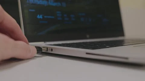 Inserting a USB drive into a laptop for data transfer, storage, or backup. Stock Footage 305125262