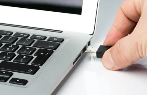 Inserting Usb key or cable into a laptop computer Stock Photos