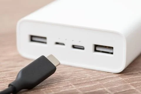 Inserting usb type c cable to white power bank Stock Photos