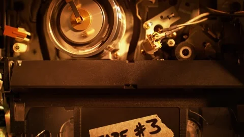 Inserting a VHS Tape - Top View of the Video Cassette Being Pushed into the VCR Stock Footage 272876740