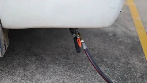 A insertion gasoline into fuel tank from a plastic red gas can.tank with 库存影片 336569543
