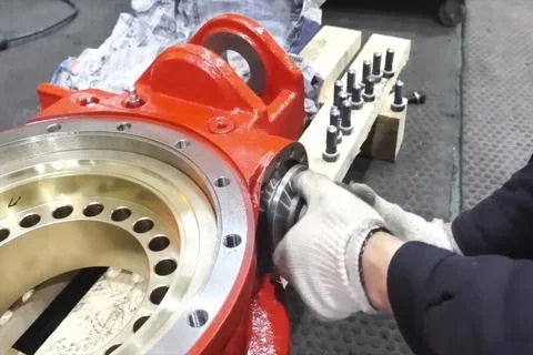 Insertion of the worm gear into the housing of the press equipment part. Stock Photos