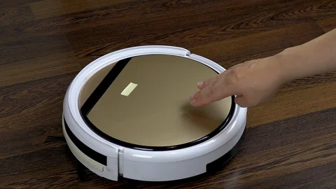 Inserts a new filter into the vacuum cleaner robot.. Automatic white round Stock Footage 123551385