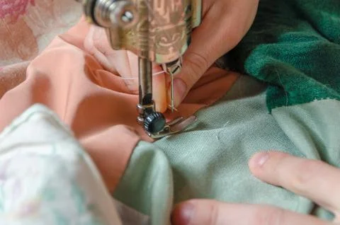 Inserts a thread into the needle of the sewing machine inserts girl 库存照片