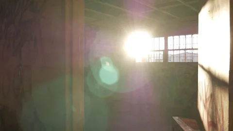 Inside an abandoned Air Force base with graffiti sun coming throw window Stock Footage