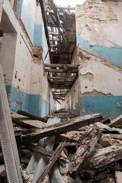 Inside an abandoned structure showcasing crumbling walls, scattered wood debr Stock Photos