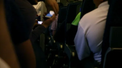 Inside airplane isle, using phones Stock Footage 125162462