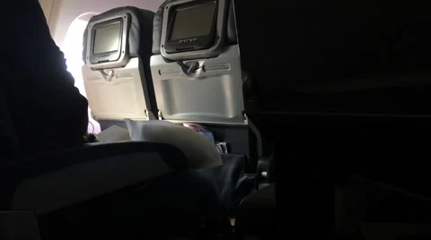 Inside airplane view of passengers and tv screens Stockbeeldmateriaal 57695838