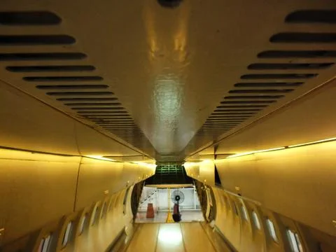 The inside of an airplane with a yellow ceiling. Stock Photos