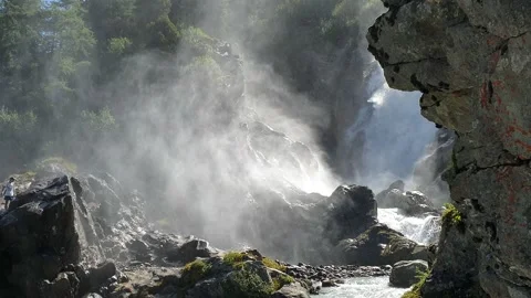 Inside an Alpine waterfall, backlight slow motion Stock Footage 137568619