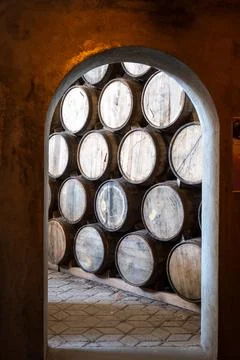 Inside an ancient tequila distillery, a stone archway frames wooden aging Stock Photos