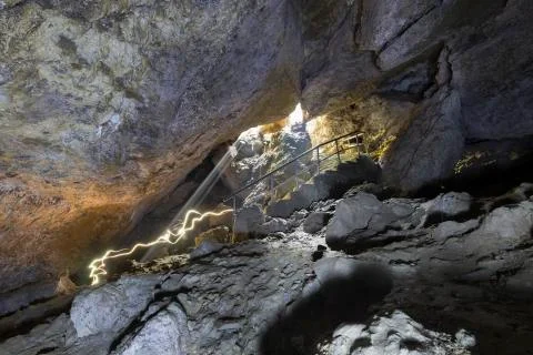 Inside batt cave people moving with light Nepal 스톡 사진