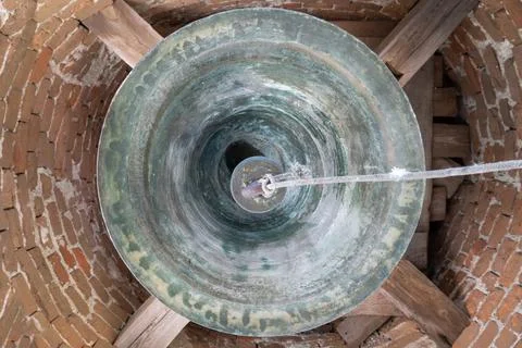 Inside the bell tower. Bottom view of a large bell. Old bell tower of red b.. Stock Photos