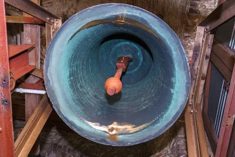 Inside the bell tower. A view from below of the big bell. An ancient red bric Stock Photos