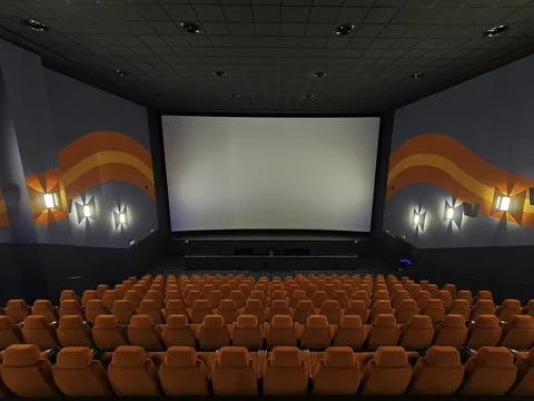 Inside of the big cinema. Empty seats waiting the movie on the white screen.  Stock Photos