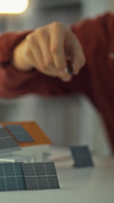 Inside bright studio engineer examines miniature 3D models houses with solar Stock Footage 331794938