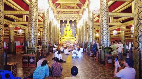 Inside Buddhist temple people praying for golden statue at Wat Phra Si Rattana Stock Footage 341661367