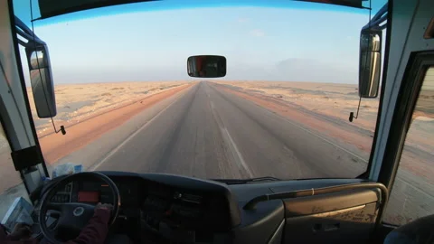 Inside of a bus with tourists driving on the empty desert road in Sahara, Egy Stock Footage 236964092
