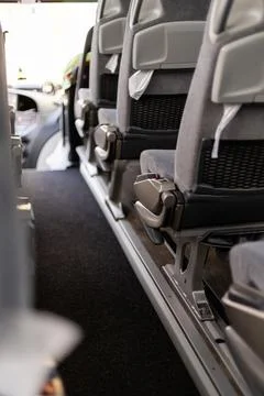 Inside the bus, the view shows empty seats lined up with a clear aisle. Sunli Stock Photos