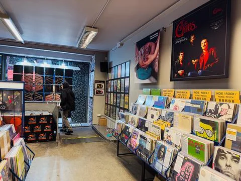 Inside a bustling vinyl record store with shelves of albums and retro poste.. Stock Photos