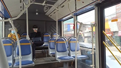 INSIDE OF BUSWAY, PEOPLE SIT WITH PSYCAL DISTANCING Stock Footage 159089613