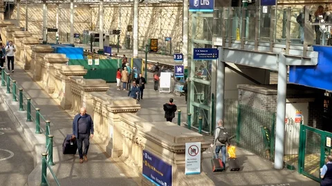 Inside busy Edinburgh station, with passengers walking to and from platforms. Video stock 106895052