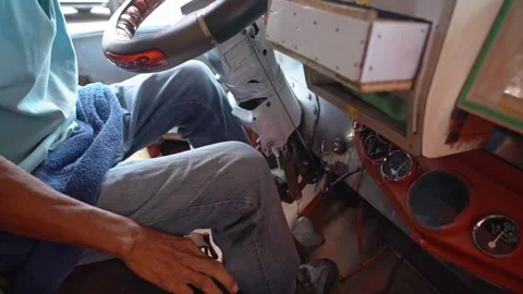 Inside of the cab of a Jeepney vehicle with driver steering the vehicle. Video stock 278436915