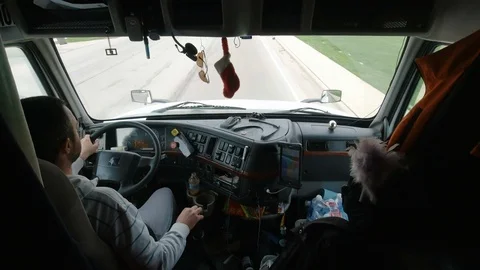Inside the cabin of a semi truck. Middle aged male driver driving Stock Footage