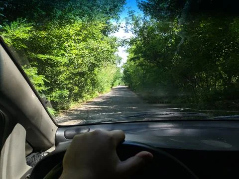Inside the car. driver behind the wheel. drive a car. journey. bad roads. by  Stock Photos