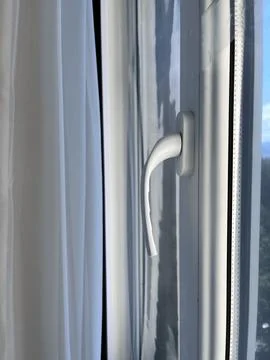 The inside of a car with a focus on the window handle. The car is parked, and Photos