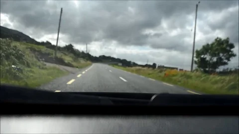 Inside a Car Riding through a National Road with Green Vegetation in Ireland Stock Footage 77838271