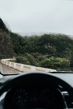 Inside car view driving down a winding road with a mountain in the background Stock Photos