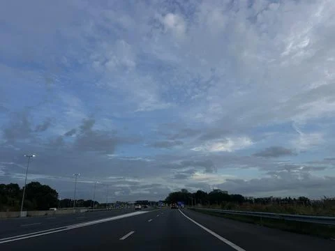 Inside car view of multilane highway ring road commute at dusk under dramatic Stock Photos