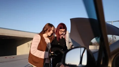 Inside car view women test ideas to fix engine Video stock 332871938