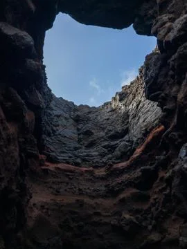 INSIDE OF THE CAVE LOOKING UP AT THE BLUE SKY Foto stock