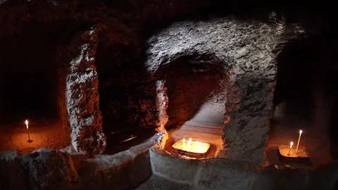 Inside the cave of St. Tabitha. Candles are burning. Prayer. Stock-Footage 145100380