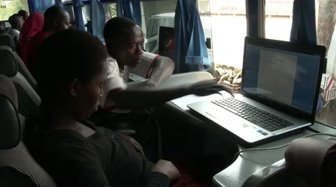 Inside a computer classroom in africa - Teacher helping student Stock Footage 47848931