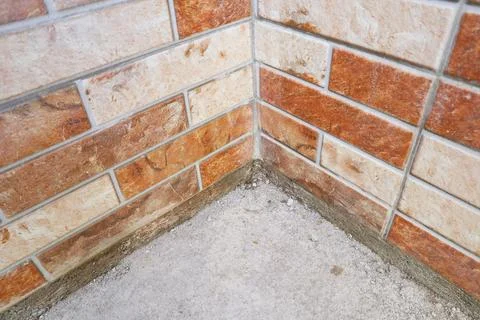 Inside corner view of an orange and beige split-face decorative brick tile .. Stock Photos