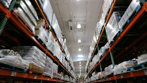 Inside a Costco Wholesale warehouse store with tall shelving stocked with bulk Vidéo 345478677