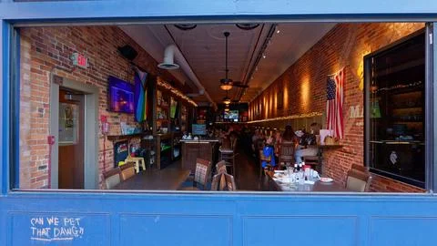 Inside A Cozy Brick Restaurant Seen Through An Open Window Stock Photos