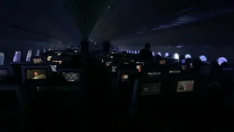 Inside dark cabin of long haul international 787 aircraft in flight Stock Footage 323778516