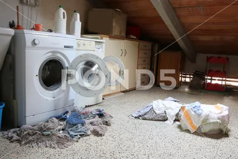 Inside a dusty attic of a school with two big washing machines and tatters di Stock Photos