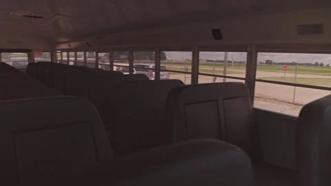Inside an empty school bus, from the driver seat to rows of empty seats Video stock 347731547