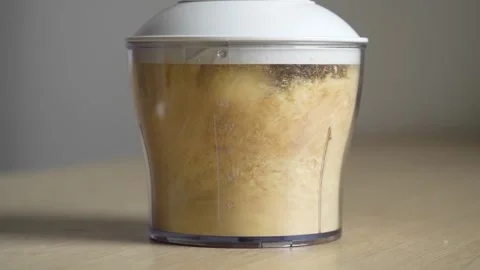 Inside glass cup blender grinds orange pieces of hedgehog mushroom. Stock Footage 262046384